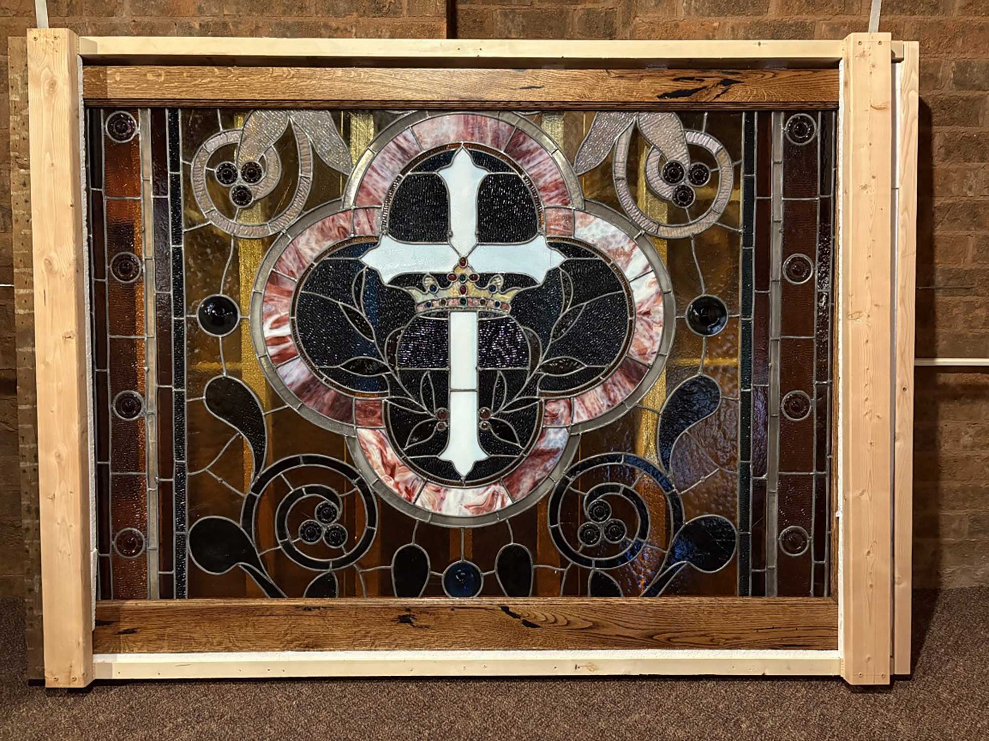 Portrait of Tyler Lukridge smiling warmly outdoors, surrounded by summer greenery.